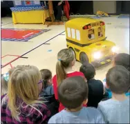  ?? Westside Eagle Observer/SUSAN HOLLAND ?? First-grade students at Glenn Duffy Elementary School crowd in close to watch Buster the School Bus at their assembly. Buster taught students important lessons to ensure they stay safe when riding the school bus.