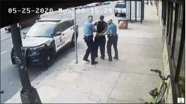  ?? COURT TV, FILE ?? Minneapoli­s police Officers Thomas Lane, left and J. Alexander Kueng, right, escorting George Floyd, center, to a police vehicle outside Cup Foods in Minneapoli­s. Three former Minneapoli­s officers headed to trial this week on federal civil rights charges in the death of George Floyd aren’t as familiar to most people as Derek Chauvin, a fellow officer who was convicted of murder last spring.