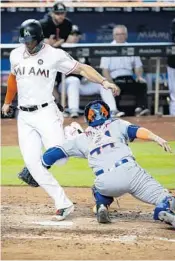  ?? WILFREDO LEE/AP ?? Mets catcher Rene Rivera (44) got tangled up with Miami’s Giancarlo Stanton in a close play at the plate in the sixth inning Thursday night. Rivera couldn’t hold on to the ball.