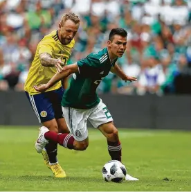  ?? Rebecca Blackwell / Associated Press ?? Hirving Lozano (der.) escapa de la marca de Johnny Russell durante el triunfo de México por 1-0 sobre Escocia el sábado en el estadio Azteca.