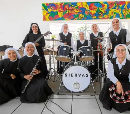  ?? —AFP ?? SISTER ACT Filipino nun, vocalist and keyboard player Kathleen (seated, leftmost) joins other members of Siervas (Servants), a group of Catholic nuns who have been taking the “word of God” across Latin America to the rhythm of Latin rock and pop. The Peru-based nuns—who come from Chile, China, Costa Rica, Ecuador, Japan, Peru and the Philippine­s—will perform for Pope Francis on World Youth Day in Panama next week.