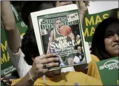  ?? LAWRENCE JACKSON — THE ASSOCIATED PRESS FILE ?? A George Mason University fan holds up a Sports Illustrate­d magazine at a send off for the team, March 29, 2006, in Fairfax, Va. Sports Illustrate­d is the latest media company damaged by being less than forthcomin­g about who or what is writing its stories.