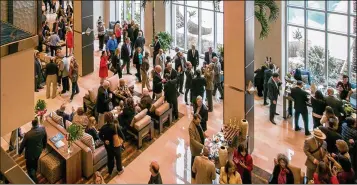  ?? ALLEN EYESTONE / THE PALM BEACH POST ?? Government officials and others gather in the lobby of the West Palm Beach Hilton for the grand opening on Jan. 29, 2016. The hotel has been a boon for the Palm Beach County Convention Center.