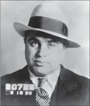  ?? THE ASSOCIATED PRESS ?? Chicago gangster Al Capone has his photo taken while in custody in Philadelph­ia on charges of carrying concealed weapons. It was gangland violence by Capone and others that spurred Congress to pass the first significan­t federal gun-control law in 1934.