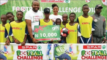  ??  ?? Marketing Manager, SPAR Nigeria, Emmanuel Patrick, (2nd left) and Quality Control Manager, Maria Oyewusi, presenting the Overall Best School Award to students of Ajumoni Junior Secondary School, during the ongoing SPAR Football Challenge at the Ilupeju...