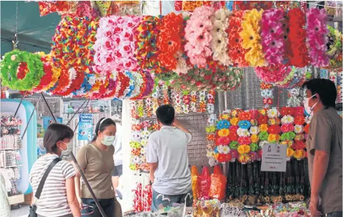  ?? APICHART JINAKUL ?? People browse products at Sampheng market in Bangkok.