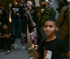  ?? MAJDI MUHAMMAD/ASSOCIATED PRESS ?? A Palestinia­n child held a rifle during the funeral of Qasim Qasim, 23, in the West Bank city of Tulkarem on Saturday. Qasim was killed in clashes with Israeli forces.