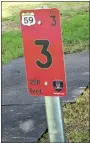  ?? Photo by Mike Eckels ?? The tee marker on Hole No. 3 at the Veterans Park disc golf course in Decatur gives players informatio­n as to distance to hole and number of shots (par).