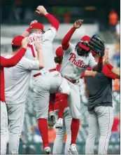  ?? PAUL SANCYA — THE ASSOCIATED PRESS ?? Philadelph­ia Phillies’ players Rhys Hoskins and Roman Quinn celebrate with teammates after beating the Detroit Tigers in Detroit, Wednesday.