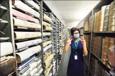  ?? Hearst Connecticu­t Media file photo ?? Stamford Town Clerk Lyda Ruijter stands between shelves of Stamford town records in storage at the Stamford Government Center on July 17.