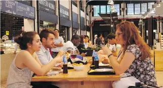  ??  ?? Diners sit down for a meal at one of the communal tables in the Mercado da Ribeira, a food hall adjacent to Lisbon’s largest farmers’ market. Go early because its popularity makes it difficult to find a spot after 8 p.m.