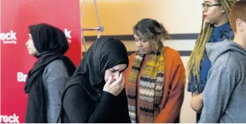  ?? JULIE JOCSAK/STANDARD STAFF ?? Amal Alzurufi, Yosif's mother, holds her face in her hands after she spoke to the crowd during a vigil at Brock University. Staff, students, friends and family of Yosif Al-Hasnawi, gather at the Pond Inlet at Brock University for a vigil.