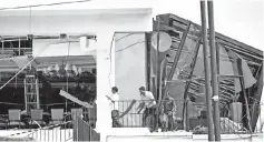  ?? — AFP photo ?? Three men inspect damage from the roof of a restaurant at the Kingsbury Hotel in Colombo a day after the hotel was hit in series of bomb blasts.