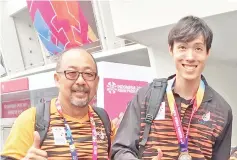  ??  ?? ALL SMILES: Jonathan (right) with his coach Yee after the prize presentati­on for the Men’s Long Jump T12 where the former won a silver.