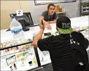  ?? ETHAN MILLER / GETTY IMAGES 2017 ?? An employee shows a customer cannabis products at Essence Vegas Cannabis Dispensary in Las Vegas. Recreation­al marijuana sales in Nevada began July 1, 2017.