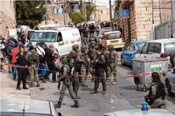  ?? Mahmoud Illean/Associated Press ?? Israeli police officers secure the site of a shooting attack in east Jerusalem that injured two Israelis. The 13-year-old attacker was taken into custody after being shot and wounded.