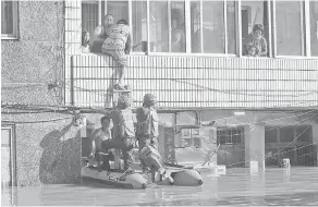  ?? — Gambar Reuters ?? BANTU: Pekerja penyelamat membantu penduduk yang terkandas dalam banjir selepas Taufan Lekima melanda bandar Linhai di Taizhou, wilayah Zhejiang, China kelmarin.