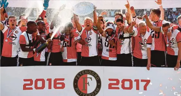  ??  ?? Feyenoord’s Dirk Kuyt shows off the championsh­ip trophy after winning the Dutch Eredivisie on Sunday.