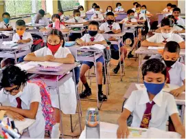  ??  ?? School in Minuwangod­a: Following primary precaution­s such as wearing masks and keeping social distance. Pix by Priyanthe Wickramaar­achchi
