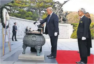  ?? POOL PHOTO BY JEON HEON- KYUN ?? President Trump burns incense during his visit Wednesday to the National Cemetery in Seoul.