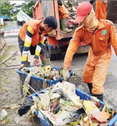  ?? ADEK BERRY/AFP ?? Workers remove garbage from the Ciliwung river in Jakarta on November 29. The Jakarta city administra­tion has hired workers to clean up the city’s rivers, canals and lakes.