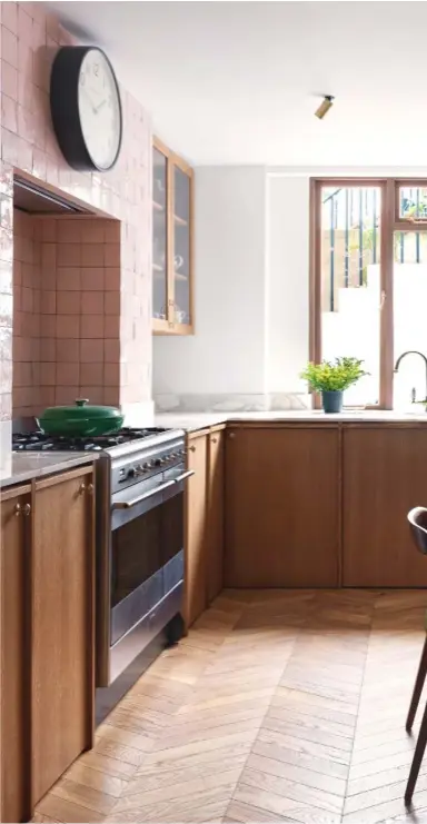  ??  ?? Kitchen Honey-toned oak panelling and cabinetry by Sygnet Style Ltd joiners is complement­ed by a gold-flecked marble countertop and pastel pink zellige tiles from Mosaic Del Sur. The table and chairs are by Jader Almeida for Sollos, while the pendant
light above is a vintage find from the 1970s