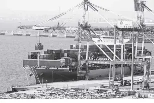  ?? AP/KOJI SASAHARA ?? A CONTAINER ship is loaded and unloaded at a container terminal at a port of Kawasaki near Tokyo on March 9, 2022. Japan’s trade deficit surged to over 2 trillion yen ($15 billion) in November as higher costs for oil and a weak yen combined to push imports sharply higher.