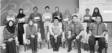  ??  ?? Kipli (seated centre) and Ong on his left in a group photo with Macma Sarawak committee members and recipients of the education incentives.