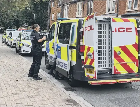  ??  ?? SHOCKING A police officer stands by a police van in Alexandra Road where a suspect had been detained following a robbery