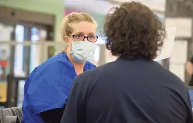  ?? H John Voorhees III / Hearst Connecticu­t Media ?? Emergency medical technician Eugenia McGovern, of Griffin Health in Derby, gathers informatio­n from Anthony Capirichio, of Danbury, a walk-in at the COVID-19 vaccine clinic at Danbury Library on Friday.