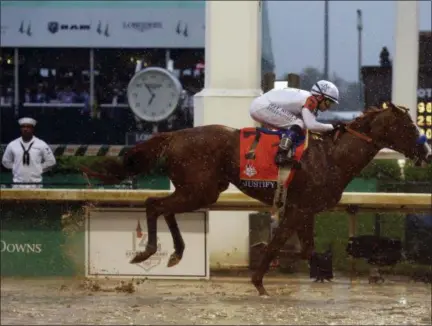  ?? KIICHIRO SATO — THE ASSOCIATED PRESS ?? Mike Smith rides Justify to victory during the 144th running of the Kentucky Derby horse race at Churchill Downs Saturday in Louisville, Ky.