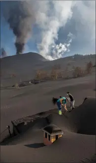  ?? ?? People dig a house out of volcanic ash on La Palma, Spain