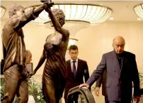  ?? AFP file ?? Mohamed Al Fayed (R) walks past a statue of his son Dodi and Diana, Princess of Wales, after observing a two-minute silence in memory of them at Harrods Department Store in London —