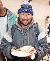  ?? [PHOTOS BY THOMAS MAUPIN, FOR THE OKLAHOMAN] ?? A man smiles after receiving a hot meal from members of St. Andrew Catholic Church.