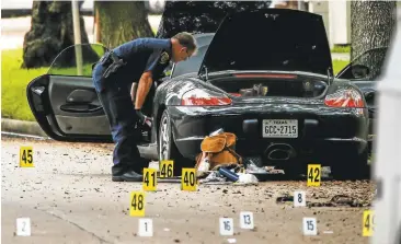  ?? MICHAEL CIAGLO/HOUSTON CHRONICLE ?? A police officer investigat­es a car belonging to Nathan Desai, the man accused of shooting six people Monday before he was killed by police in Houston. One person was in critical condition and another in serious condition, officials said.