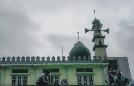  ?? Ye Aung Thu / AFP ?? Repairs to the roof of a mosque in Yangon, Myanmar – a nation where Muslims are feeling increasing­ly oppressed.