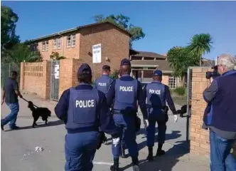  ?? Photo: Sphiwe Hobasi SABC ?? Police and sniffer dogs make their way into Thembaleth­u High during a previous raid at the school.