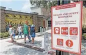  ?? JOHN RAOUX/AP ?? Signs remind people of coronaviru­s safety protocols at the Disney Springs complex in Lake Buena Vista, Florida.