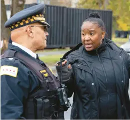  ?? BRIAN CASSELLA/CHICAGO TRIBUNE ?? Chicago police Cmdr. William Betancourt of the 10th District speaks with Ald. Monique Scott, 24th, on Oct. 29 at the scene of a shooting that wounded 15 people on South Pulaski Road in North Lawndale.