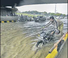  ?? BIPLOV BHUYAN/HT PHOTO ?? A man pushes his motorcycle across a water-logged stretch near AIIMS in New Delhi on Saturday.