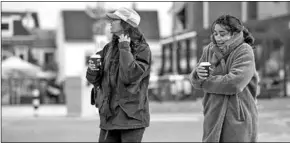  ??  ?? Twee dames met een beker koffie op straat. (Foto: De Telegraaf)