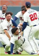  ?? TODD KIRKLAND/ AP ?? The Braves’Dansby Swanson is tackled after hitting the winning two- run single in the ninth to beat the Marlins.