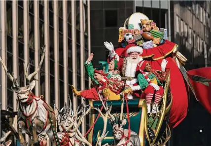  ?? Jeenah Moon/associated Press ?? Santa Claus waves from a float during last week’s Macy’s Thanksgivi­ng Day Parade in New York. Some Santas who stayed home the last two years out of concern for their health have gone back to work this holiday season.