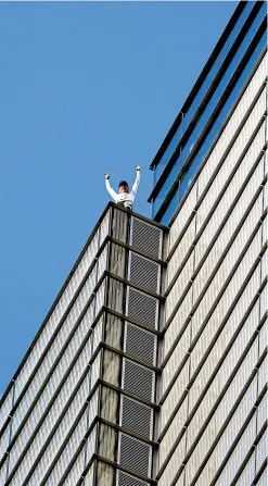  ?? AP ?? Urban climber, dubbed the French Spiderman, Alain Robert celebrates after he scaled the outside of the Heron Tower building in London.