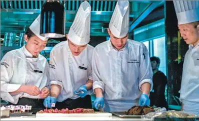  ?? FRED DUFOUR / AFP ?? Cooks cut US beef during a promotiona­l event in Beijing over the weekend.