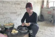  ??  ?? A woman peels a potato from her own field, in her cave dwelling in Lin county.