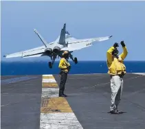  ??  ?? AN APR. 10 PHOTO shows air traffic controller­s on the flight deck while an FA18 “Hornet” fighter jet takes off, during a routine training aboard US aircraft carrier Theodore Roosevelt in the South China Sea. The carrier group Theodore Roosevelt was...