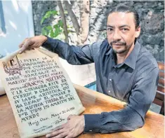  ??  ?? Raúl Campos, nieto del creador, muestra diversos objetos del archivo de su abuelo, como este reconocimi­ento otorgado por su natal Huajuapan en 1951.