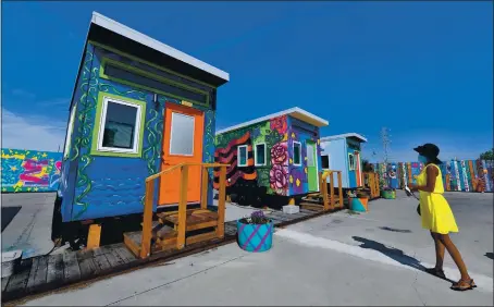  ?? PHOTOS BY JOSE CARLOS FAJARDO — STAFF PHOTOGRAPH­ER ?? Monique T. of Oakland admires a Tiny House during the grand opening ceremony of the Tiny House Empowermen­t Village in Oakland on Friday.