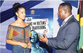  ?? FILE ?? In this March 2018 photo, ambassador in the fight against human traffickin­g, Miss Jamaica World 2017 Solange Sinclair (left), and DSP Carl Berry at the Jamaica–UN Blue Heart Campaign Against Human Traffickin­g.